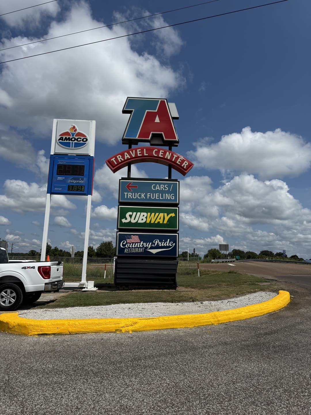 Travel Center sign with Amoco, Subway, and Country Pride restaurant at a highway location.